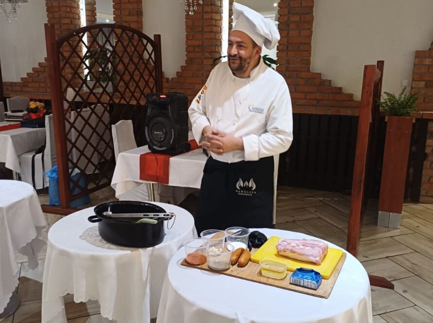 Kucharz w białym stroju prezentuje potrawy w eleganckiej restauracji.