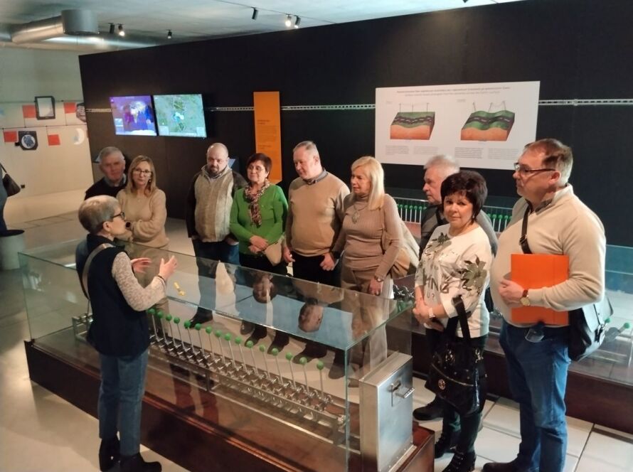 Grupa osób podczas zwiedzania wystawy z przewodnikiem w muzeum