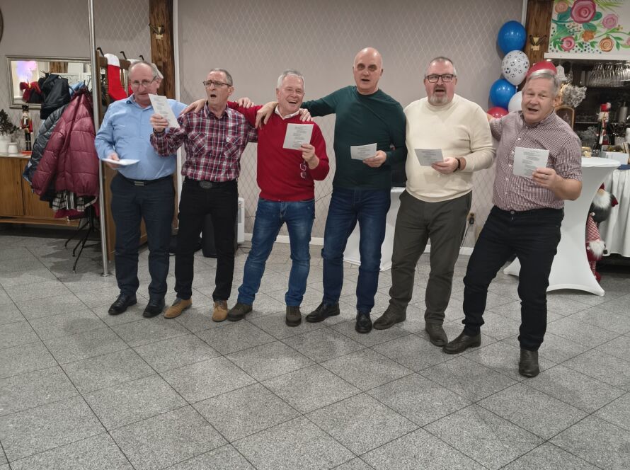 Grupa sześciu mężczyzn śpiewających razem na uroczystości.